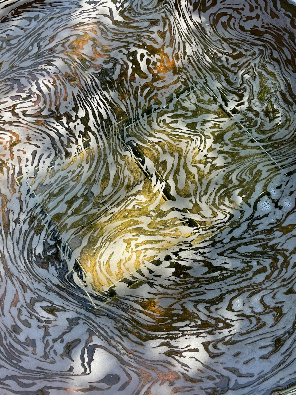 A photo of a spiraling foam pattern on a water surface
